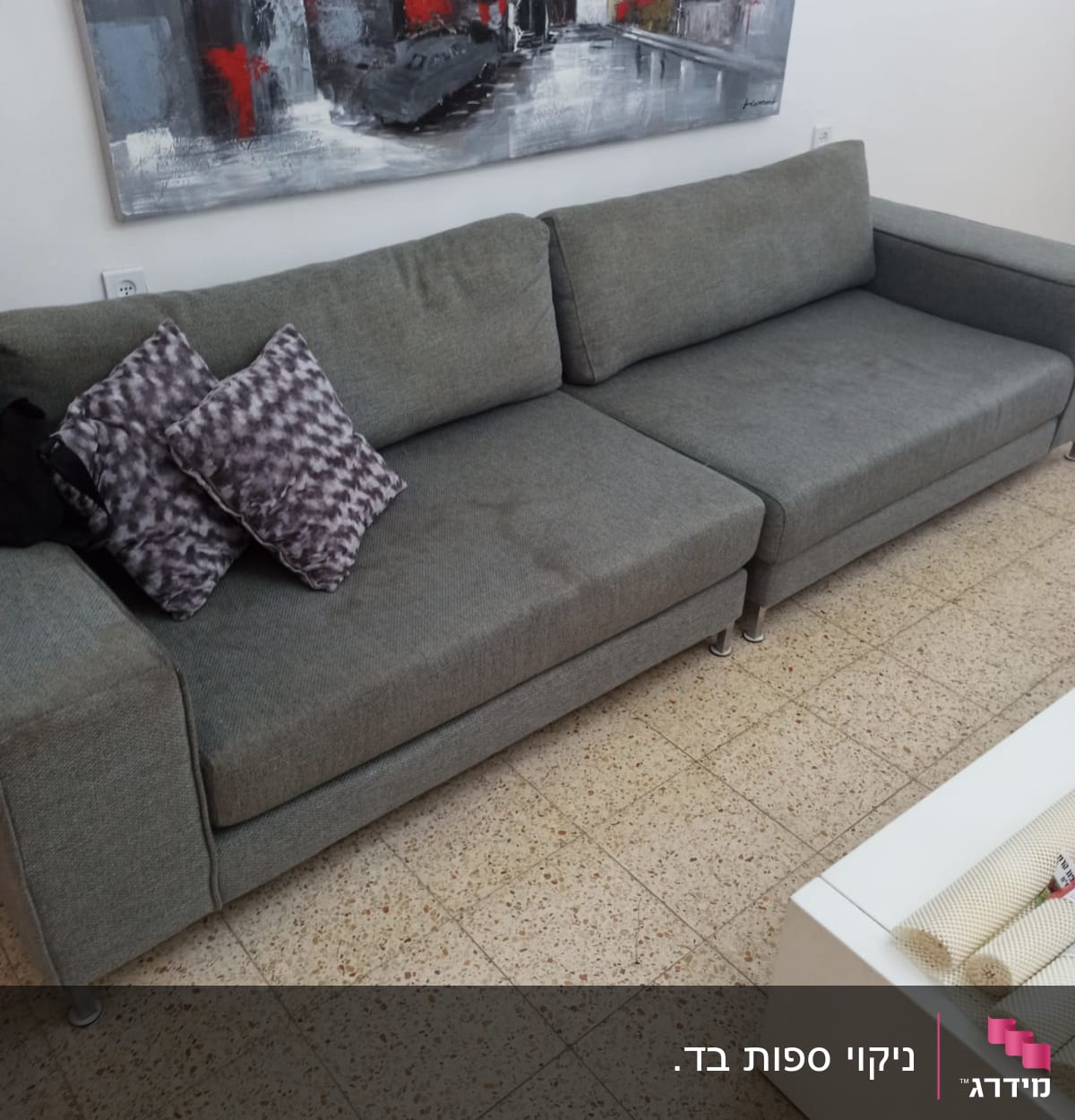 ספה אפורה עם כריות על רצפת אריחים